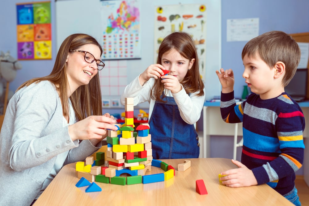 Woman And Two Children Building Legos