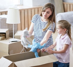 Mother And Her Daughter Packing Toys