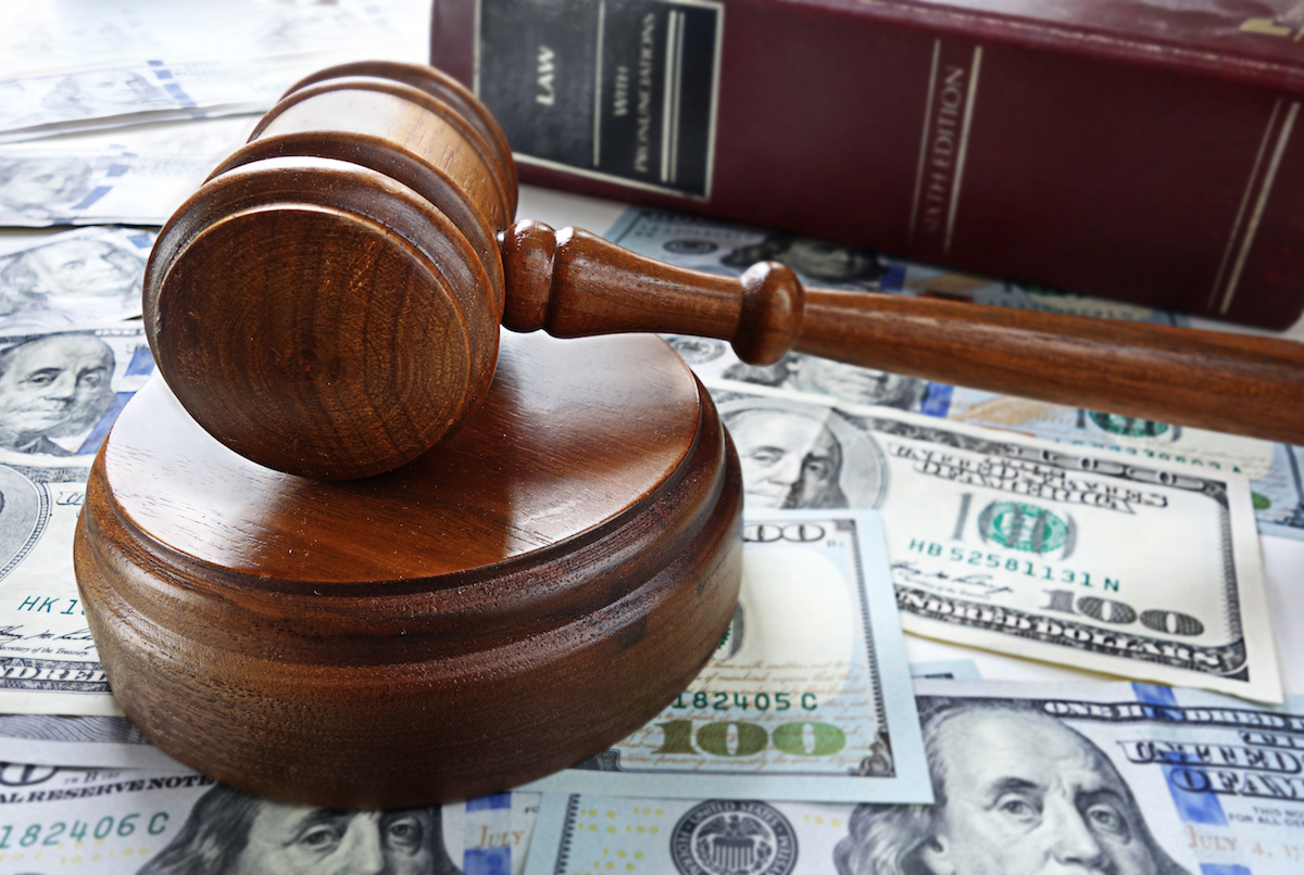 Gavel Sitting Over Spread Dollar Bills and the Book Titled Law on the Side